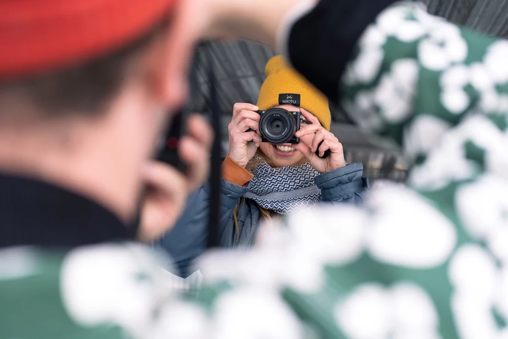 Person fotografiert jemanden aus der Perspektive der Kamera während eines Fotoworkshops.