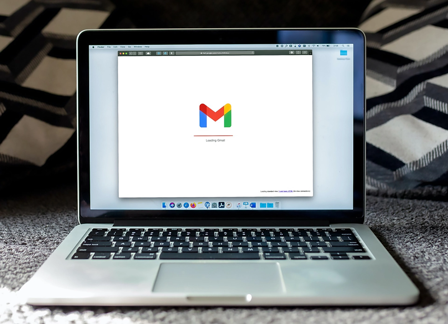 Laptop lädt Gmail, Symbol für E-Mail-Kommunikation, auf dem Bildschirm.
